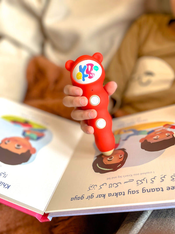 A child tapping the Bolo Pen on a Kids Bolo Urdu book